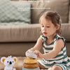 A young girl is stacking soft silicone rings and blocks for educational play on a table.