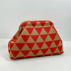 Clutch de tejido rojo y beige con patrón de diamante.