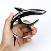 A hand holds a black shark-design guitar capo made of zinc alloy.