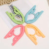 A set of ten foldable travel clothes hangers in various pastel colors including lime green, light blue, and orange.