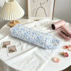A light blue floral quilted cotton hair dryer storage bag with a handle resting on a white linen cloth.