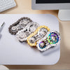 A collection of rainbow iridescent sprocket fidget spinners made of zinc alloy arranged on a white surface.
