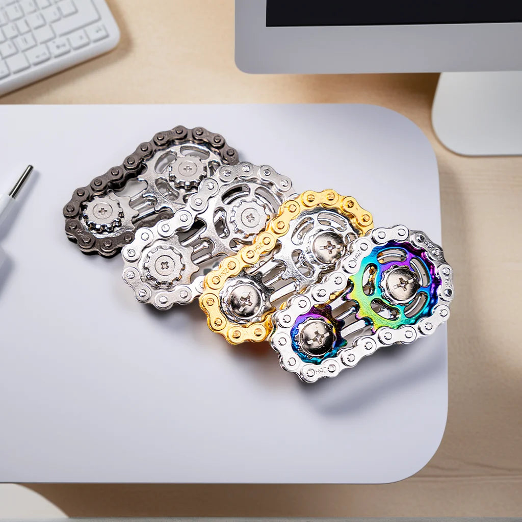 A collection of rainbow iridescent sprocket fidget spinners made of zinc alloy arranged on a white surface.