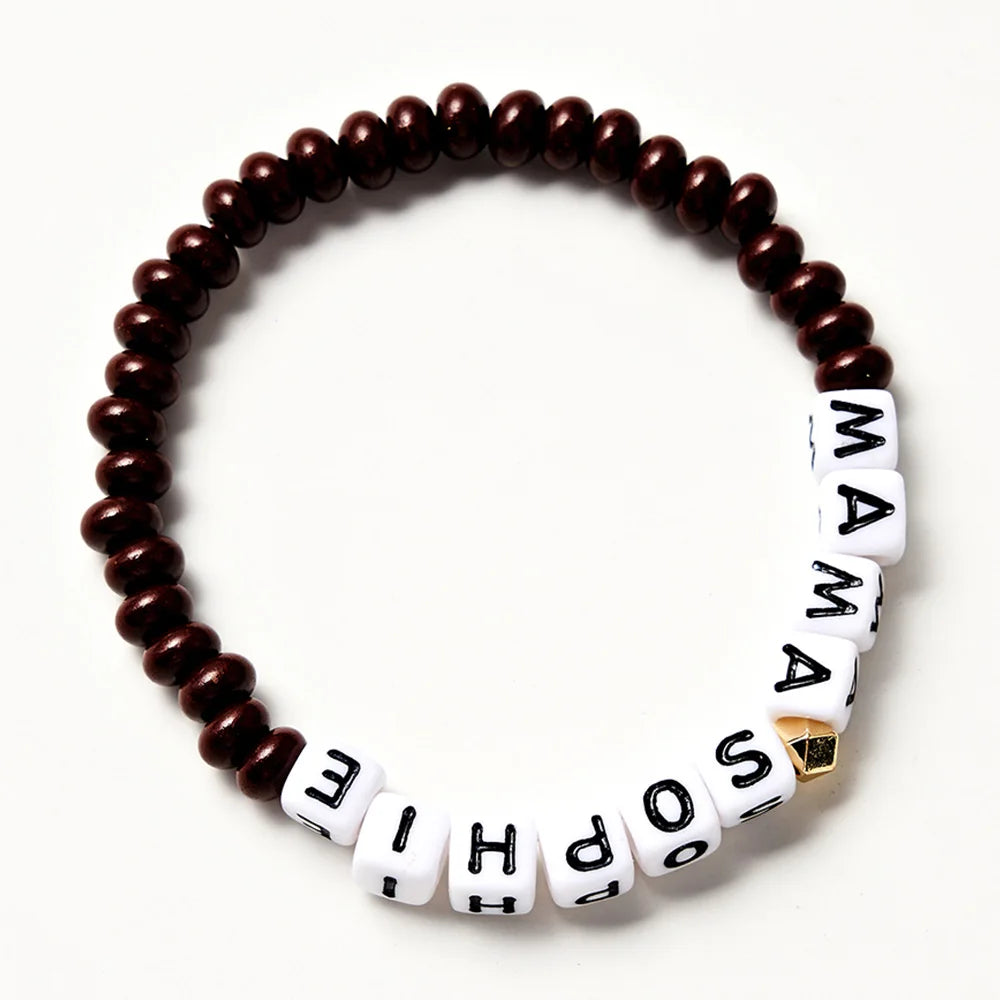Pulsera de cuentas marrón con letras blancas que deletrean una palabra.