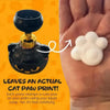 A black foam soap dispenser shaped like a cat paw is shown next to a white foam soap print on a hand.