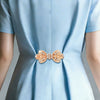 Light blue fabric with a decorative rhinestone bow knot clip detail on the chest area.