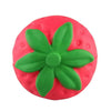 Eine leuchtend pinke, quetschbare Spielzeugform einer Erdbeere mit grünen Blättern.