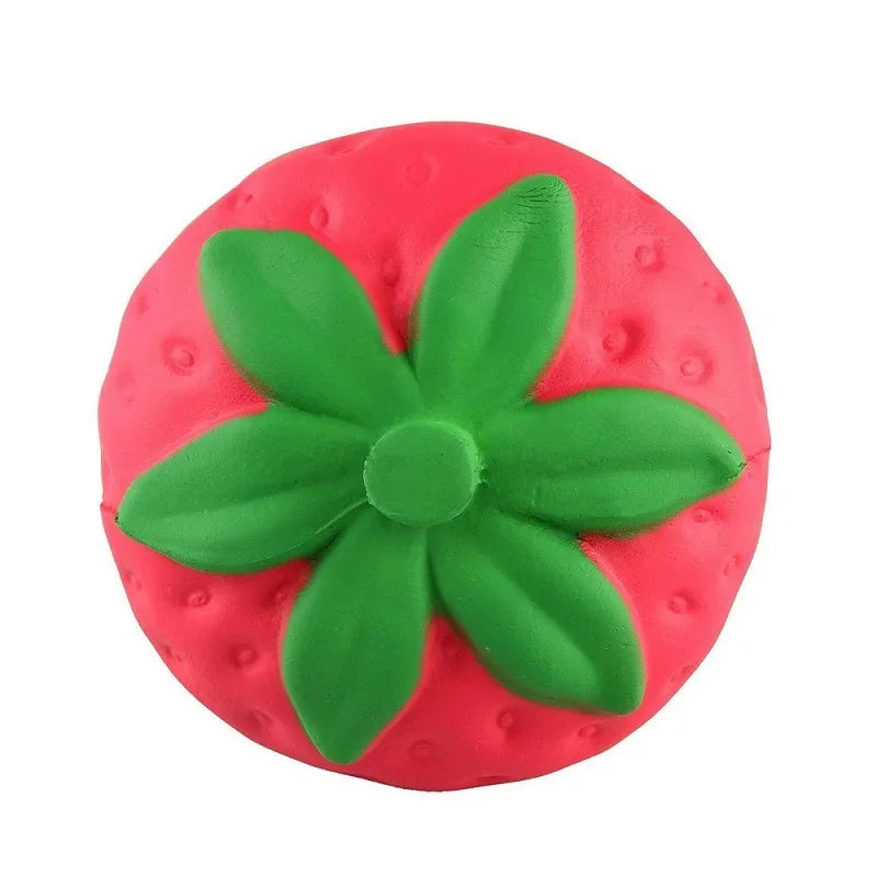 Eine leuchtend pinke, quetschbare Spielzeugform einer Erdbeere mit grünen Blättern.