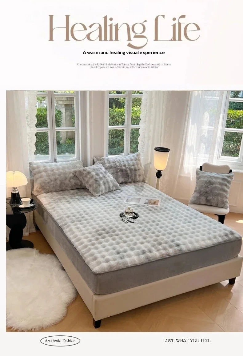 A luxury faux fur fitted sheet and pillowcase set displayed on a bed with sheer curtains.