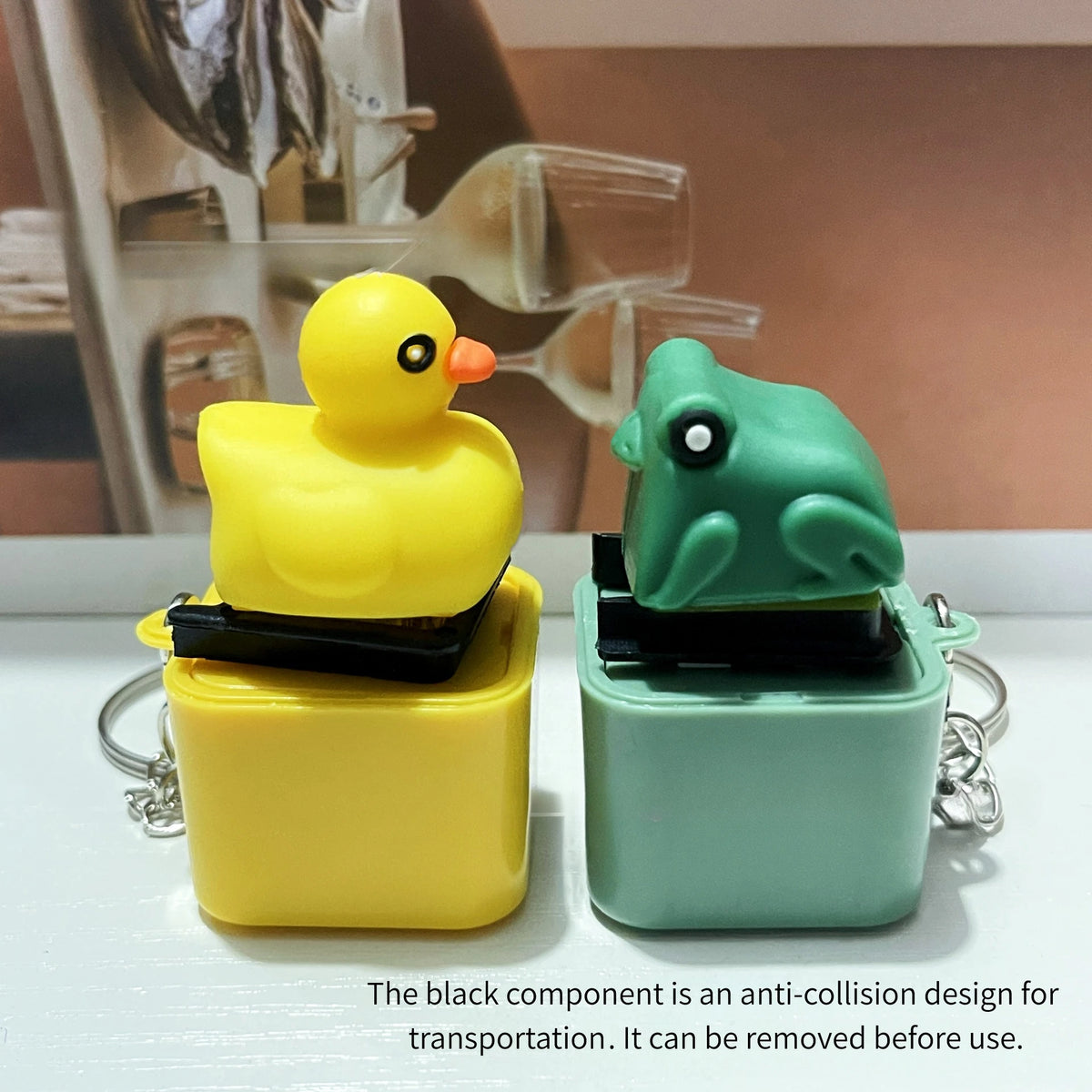 A yellow fidget keychain with a black component is shown next to a green one on a white surface.