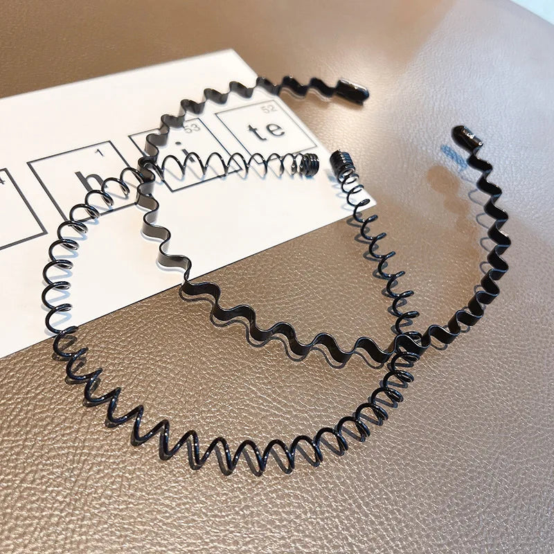 Schwarze Metal-Elastik-Headbänder mit gewellter Textur auf einer weißen Karte.