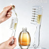 A clear silicone comb with a roller ball applicator is shown next to a glass bottle of hair growth serum.