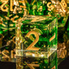 A clear green resin polyhedral dice set with gold accents, shown in a close-up view.