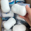 A hand holds a white squishy stress relief fidget ball packaged in clear plastic.