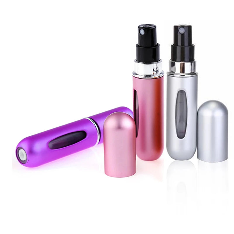 A set of five travel-friendly refillable perfume spray bottles in various metallic and pink colors.