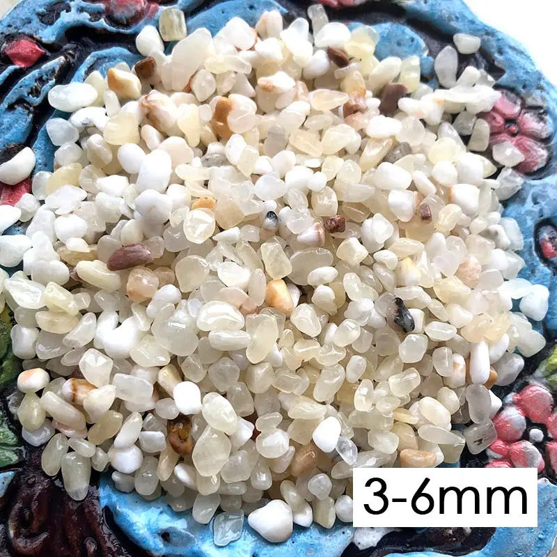 A pile of decorative stone pebbles in various shades of white, beige, and light brown.