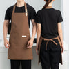 A person wearing a brown waterproof canvas chef apron over a black shirt and pants.