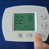 A white digital thermostat displays 82 degrees inside and 78 degrees heat setting, with fan and system options.