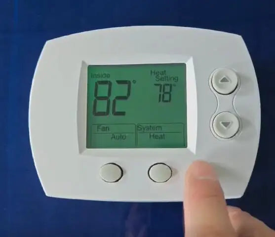 A white digital thermostat displays 82 degrees inside and 78 degrees heat setting, with fan and system options.