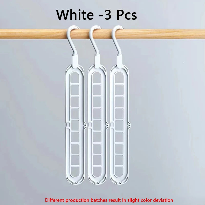 Three white folding hangers with hooks hanging from a wooden rod