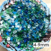 A close-up view of colorful, translucent stone pebbles in shades of blue and green.