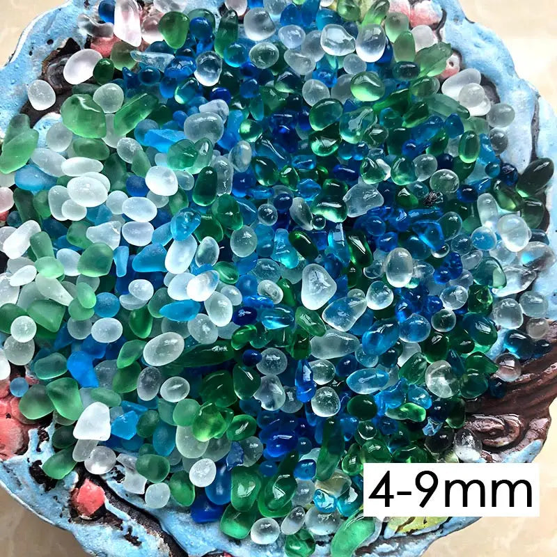 A close-up view of colorful, translucent stone pebbles in shades of blue and green.