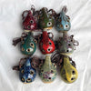 A collection of handcrafted ceramic pendant ocarinas with six holes in various earthy and vibrant colors.