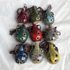 A collection of handcrafted ceramic pendant ocarinas featuring various colors and speckled designs.
