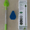 A green and silver retractable triangular floor scrubbing brush with a handle and cleaning attachments is shown next to its p