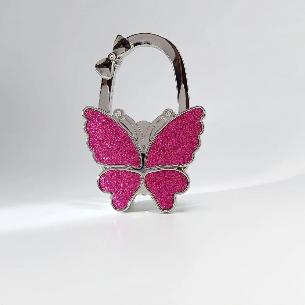 Silver butterfly shaped hook for a foldable handbag or purse.