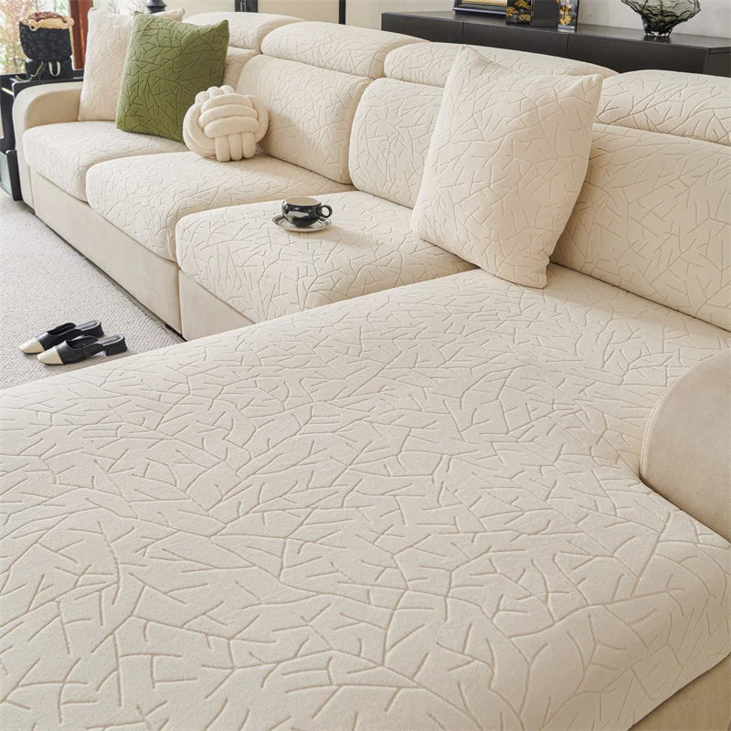 A light beige jacquard fleece sofa cover with a subtle geometric pattern and anti-slip backing.
