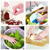 Hands wearing pink disposable nitrile gloves preparing food ingredients like pomegranate seeds and vegetables.
