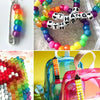 A colorful set of pony and letter beads used for crafting bracelets, displayed on a pink bag.