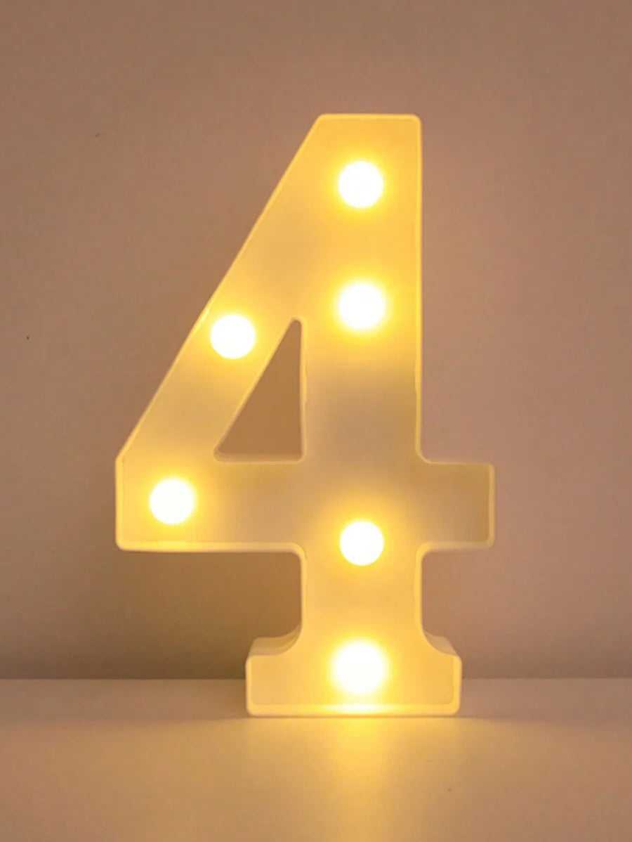 A glowing yellow LED letter night light shaped like the number four, illuminating a white surface.