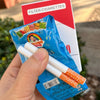A hand holds a blue packet of funny bubble blowing pipes and a red card labeled Filter Cigarettes.