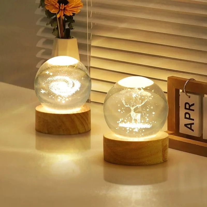 A glowing crystal ball night light with a white deer silhouette is displayed on a wooden base.