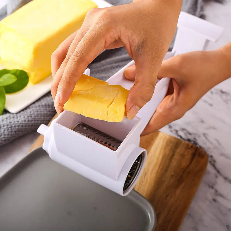 Une main utilise une râpe à fromage manuelle pour râper un bloc de fromage jaune.