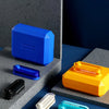 A collection of colorful metal fidget sliders and magnetic wave toys displayed on a blue surface.