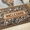 Inspirierendes Tür-Mat mit dem Wort WELCOME in Holz platziert, umgeben von glatten Flusssteinen.