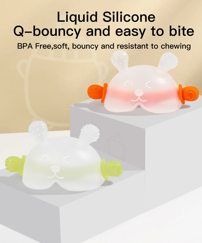 Pink and white silicone bunny-shaped baby teether with orange handles shown on a white surface.