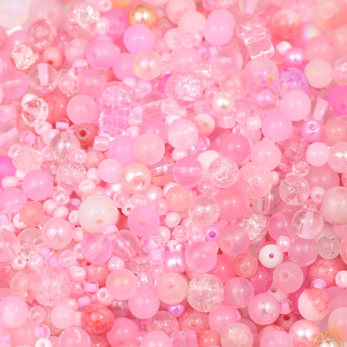 A close-up of mixed pink and clear glass beads for jewelry making