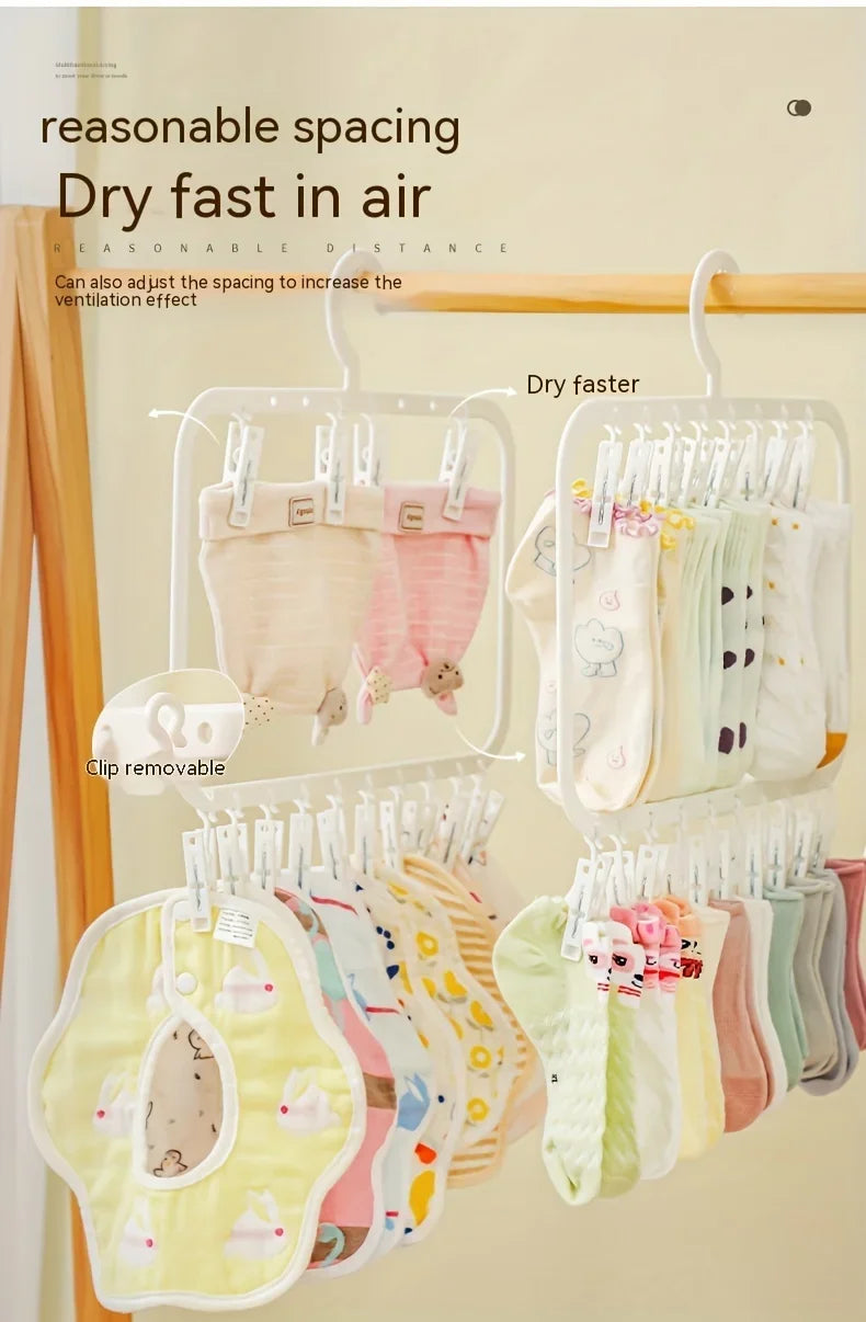 A multi-clip space-saving laundry drying rack displaying various baby clothes hanging to dry in the air.