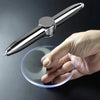 A hand holds a silver sports stress ball with a clear plastic disc underneath it.