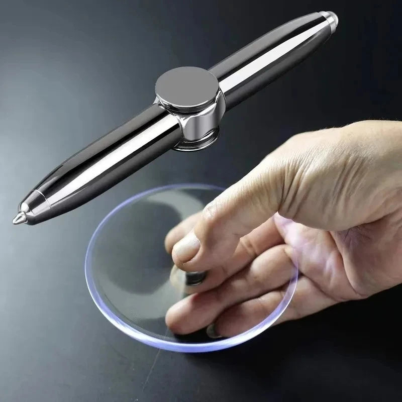 A hand holds a silver sports stress ball with a clear plastic disc underneath it.