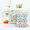 A pair of colorful, patterned mini waterproof wet dry bags for baby sitting on a white surface.