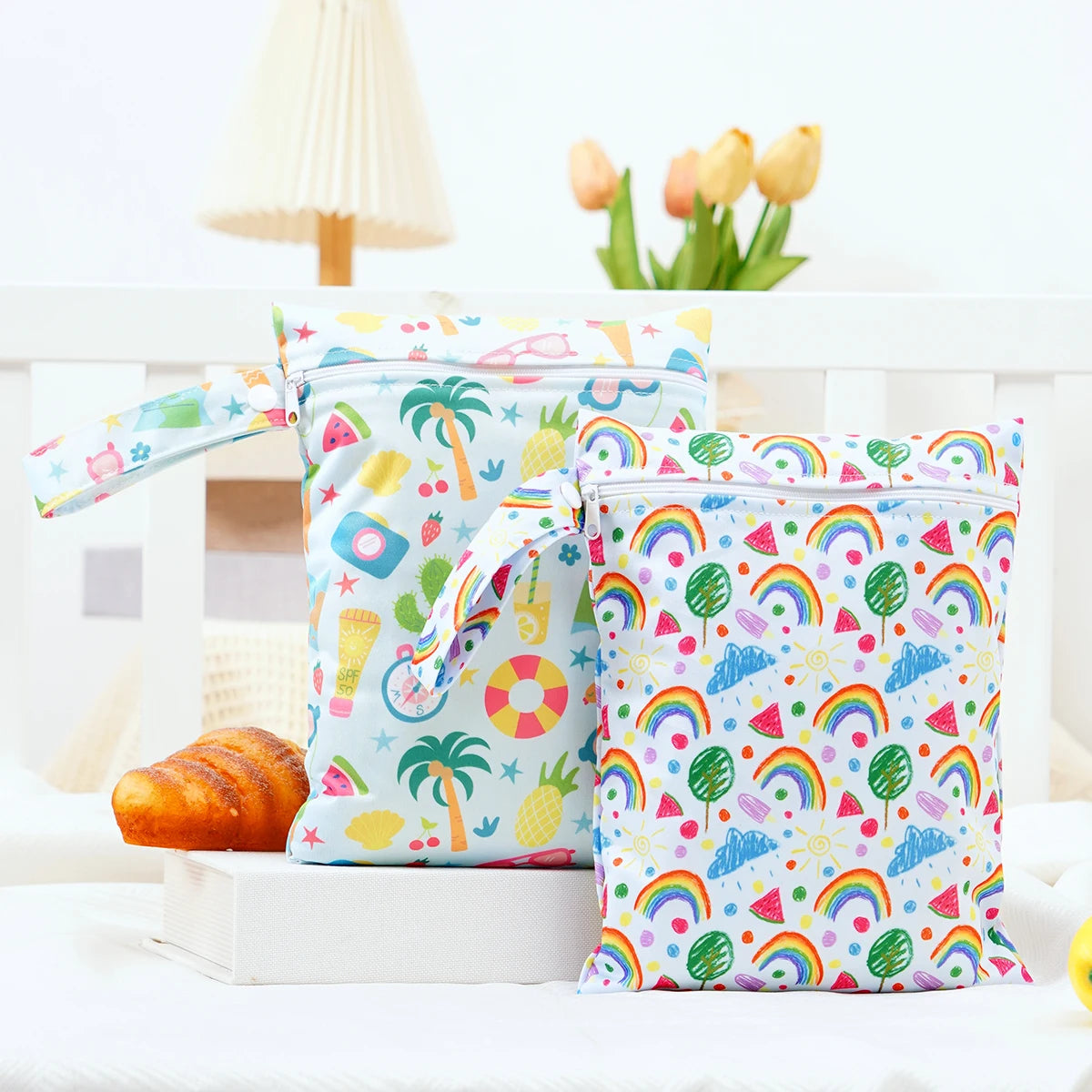 A pair of colorful, patterned mini waterproof wet dry bags for baby sitting on a white surface.