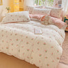 A floral duvet cover set in white with pink accents, featuring a flat sheet and pillows.