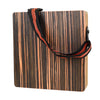A compact travel cajon drum with a wooden body and an adjustable black strap.