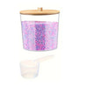 Clear acrylic detergent pod storage container with a wooden lid and a plastic spoon, filled with pink and purple pods.
