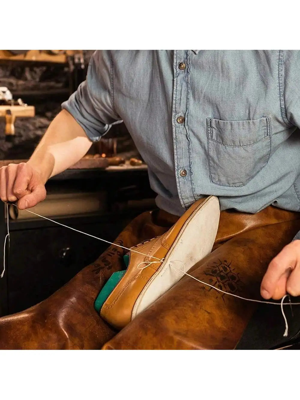 A person is using a waxed nylon thread to sew or repair leather, demonstrating the thread's use for heavy-duty work.